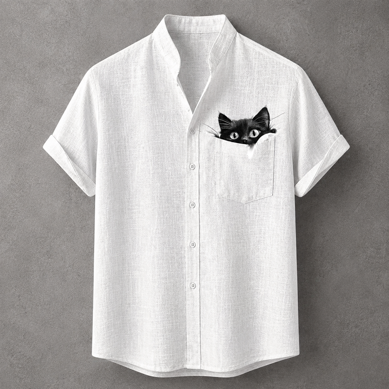 A white short-sleeve button-up shirt with a black cat peeking out of the chest pocket, displayed against a textured gray background.