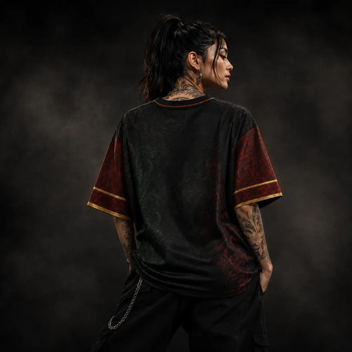 Person wearing a black and red shirt with tattoos on a dark background
