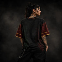 Person wearing a black and red shirt with tattoos on a dark background
