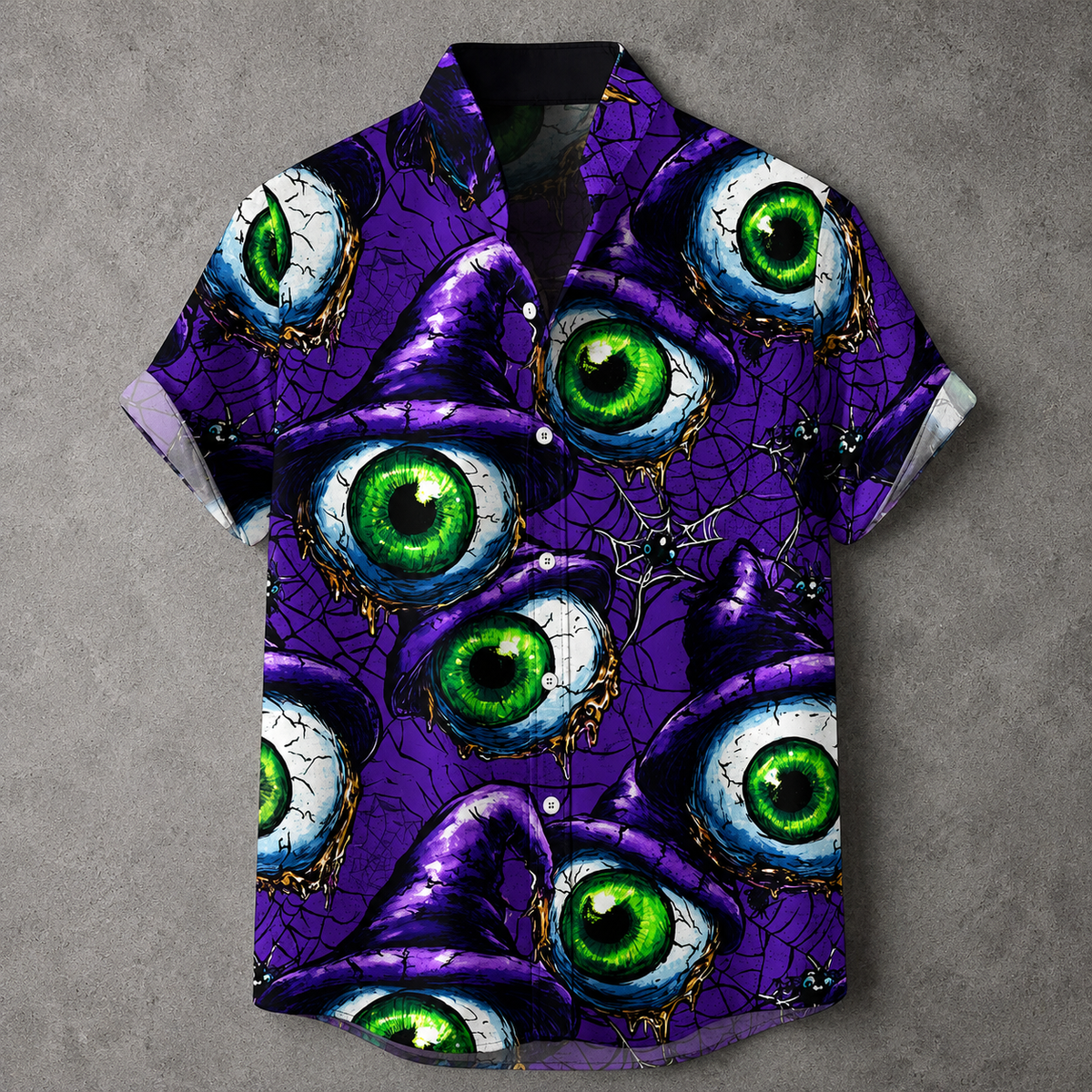 A short-sleeve button-up shirt with a vibrant purple background and an all-over print of large, detailed green and white eyeballs under cracked black and gold paint. The shirt is displayed flat against a textured gray background.