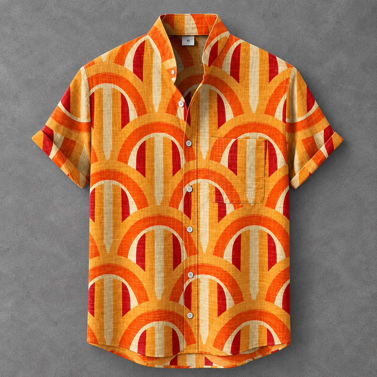 A short-sleeve button-up shirt with a retro Art Deco arch pattern in orange, yellow, red, and cream, laid flat on a textured gray background.