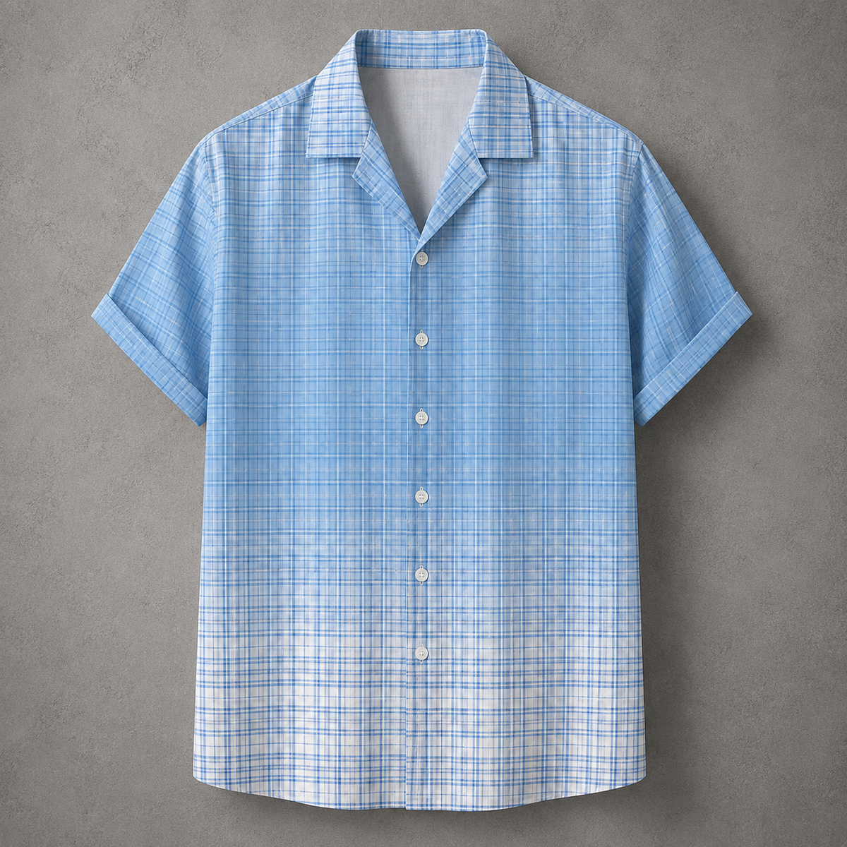 A light blue and white plaid short-sleeve button-up shirt with a camp collar, displayed flat against a textured gray background.