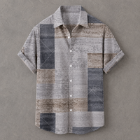 A short-sleeve button-up shirt with a textured patchwork design in shades of gray, beige, and blue, laid flat on a neutral gray background.