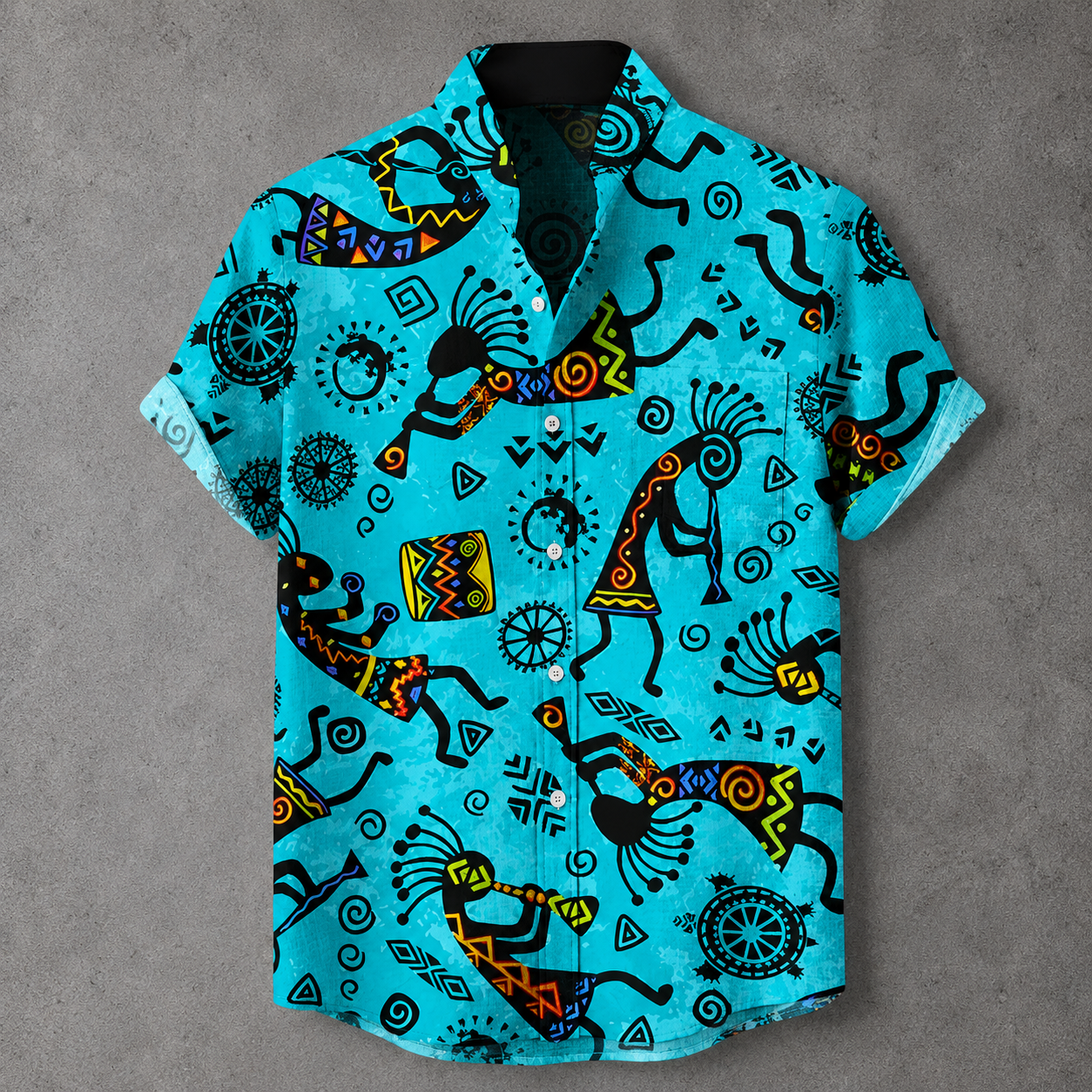 A short-sleeve button-up shirt in bright turquoise blue, featuring a bold black, yellow, and orange geometric and tribal-inspired print, laid flat on a textured gray background.