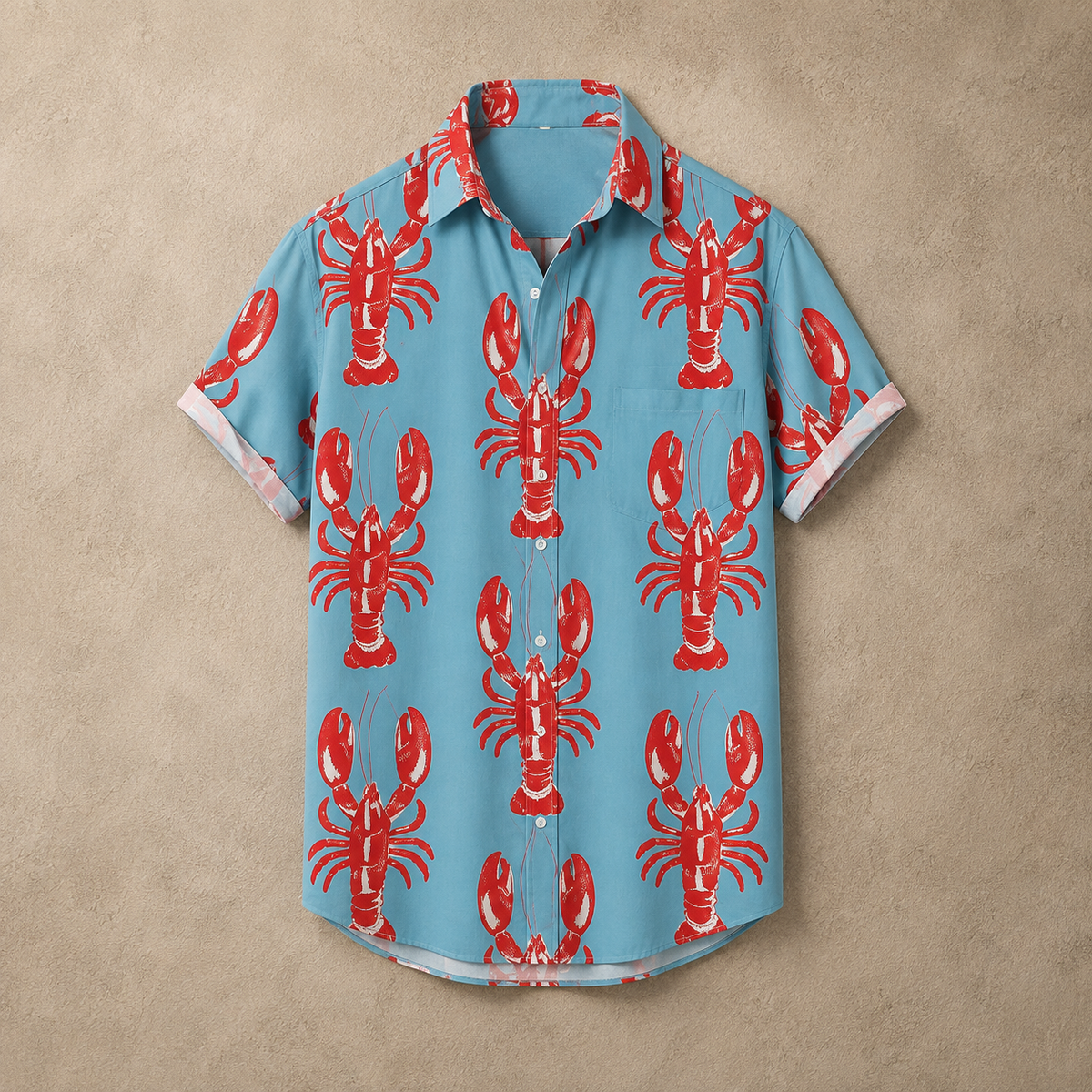 A short-sleeve button-up shirt in light blue with a repeating red lobster print, laid flat against a textured beige background.