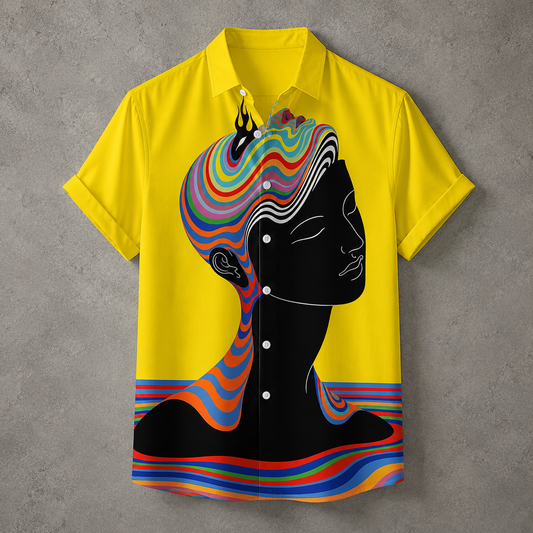 A short-sleeve button-up shirt in bright yellow, featuring a large black silhouette of a woman's profile with colorful psychedelic swirls flowing through her hair and down her neck, set against a textured gray background.